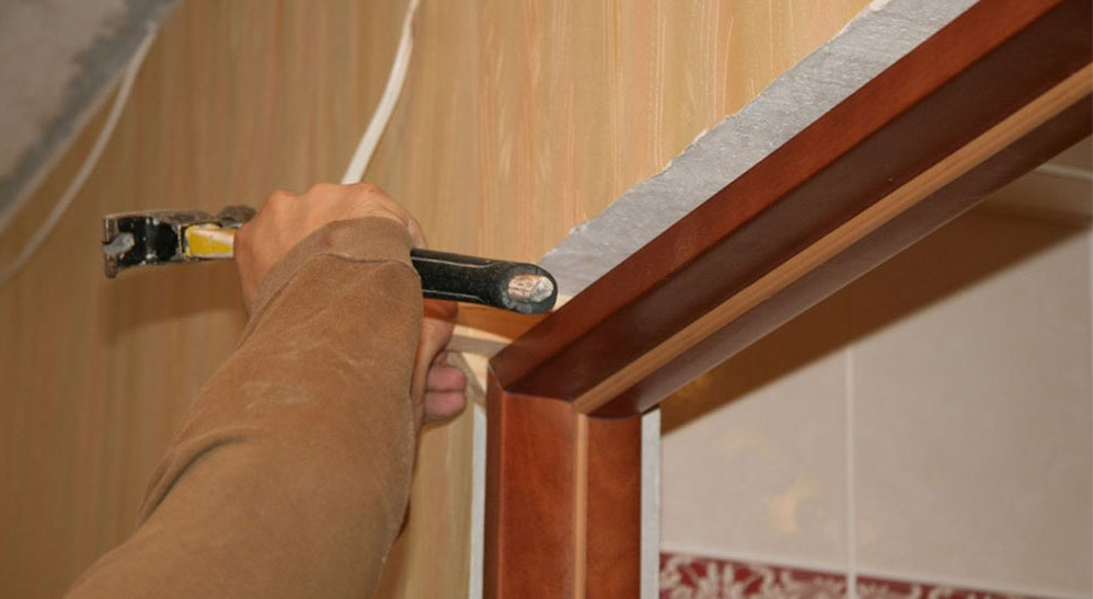 Фиксация дверной коробки с помощью клиньев 